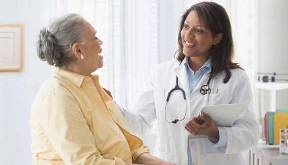 Older woman talking to doctor in office